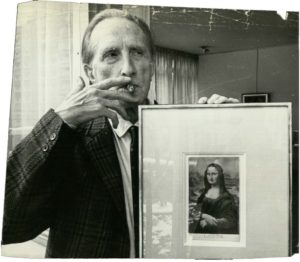 Portrait of Marcel Duchamp with his work “L.H.O.O.Q.”, ©Nat Fein, Vente Me Le Mouël, Mme Esders, Drouot, Paris, 1965.